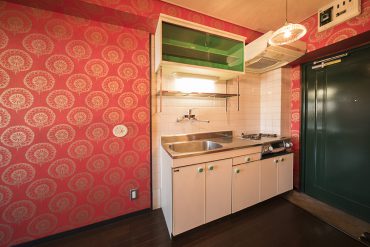 食器棚と取手の翡翠（ヒスイ）のような緑色がアクセントのキッチン。