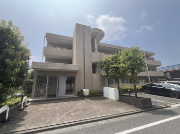 駐車場と駐輪スペースのついた3階建てのマンションです。
