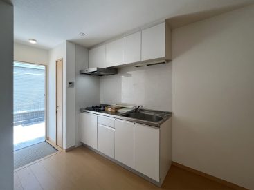 上下の収納、ガス2口のキッチン。冷蔵庫は横にすっきりと。