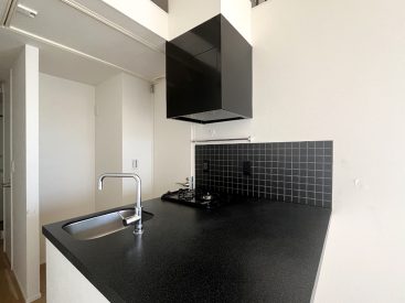 キッチンはシックにモノクロ。収納は下部分にオープンなものが。