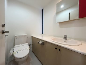 トイレと洗面は一体に。鏡の赤い収納がアクセント。