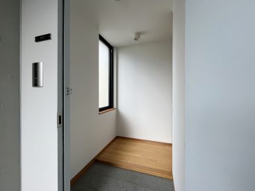ブルーグレーの玄関扉を開けて、すっきりとした印象の居室がスタート。