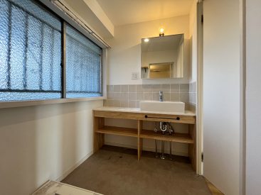 造作の洗面がある脱衣所。窓は古いまま。