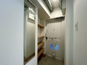 天井の配管が残る玄関。オープンクローゼットの靴箱。
