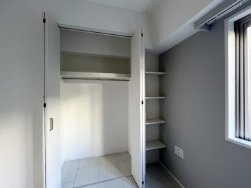 ハンガーパイプのついた収納と棚があります。