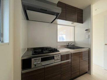 汚れが目立ちにくく、お手入れしやすい木目調パネルのキッチン。