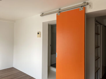 目を惹くオレンジ。工業っぽいつくりの扉がナイス。