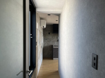 部屋を繋ぐ廊下。その途中にバルコニーへ続くドアがあります。