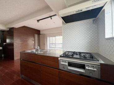 木×タイルのキッチン。3口ガスコンロにグリルがついています。